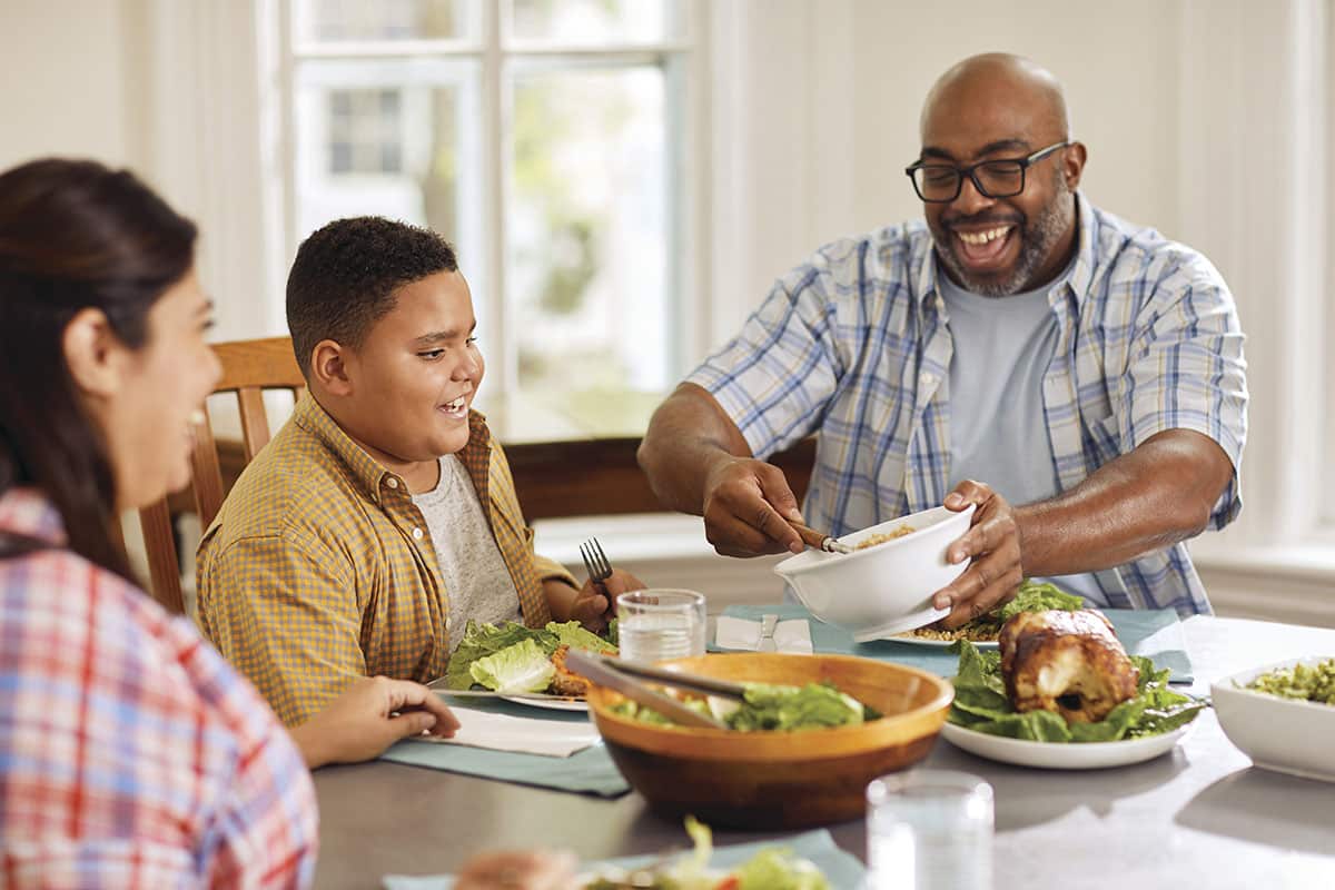 a man feeding a boy at a table