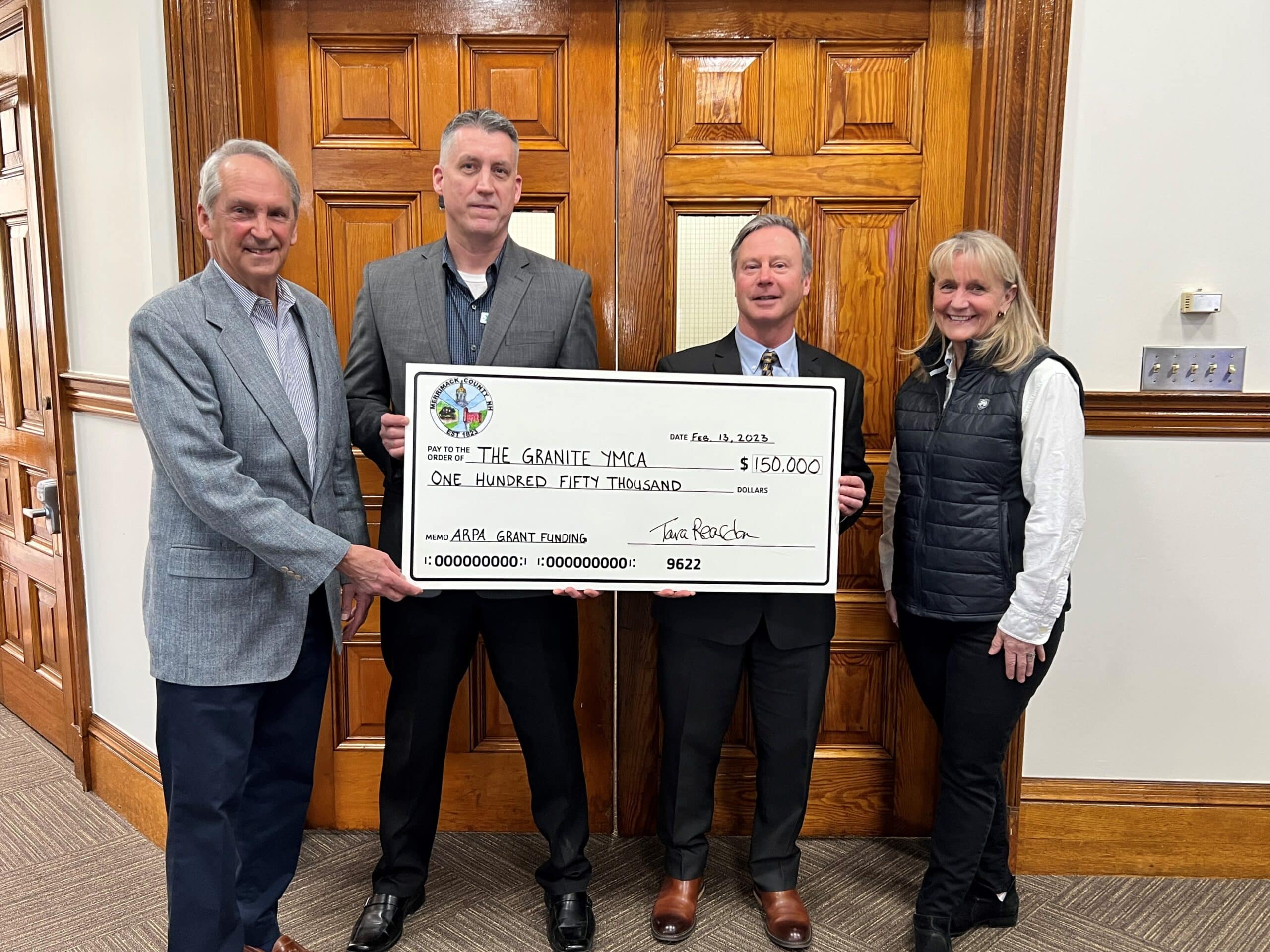 a group of people holding a check