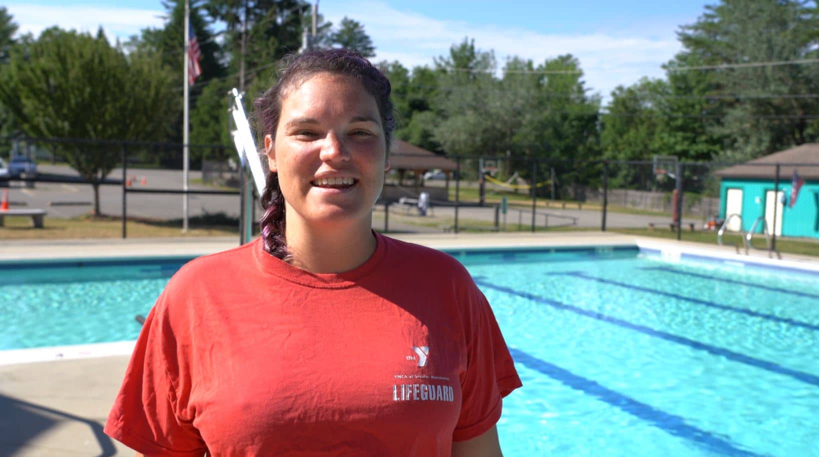 YMCA lifeguard standing by the pool participating in a training & certifications course